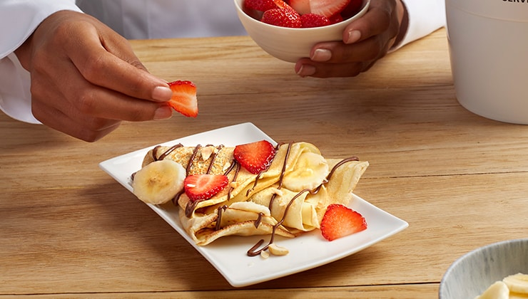 Banana cooked crepes with Nutella® and nuts
